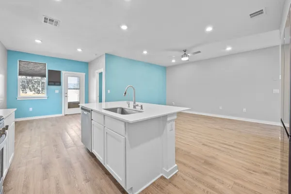 a kitchen with a sink and wooden floor