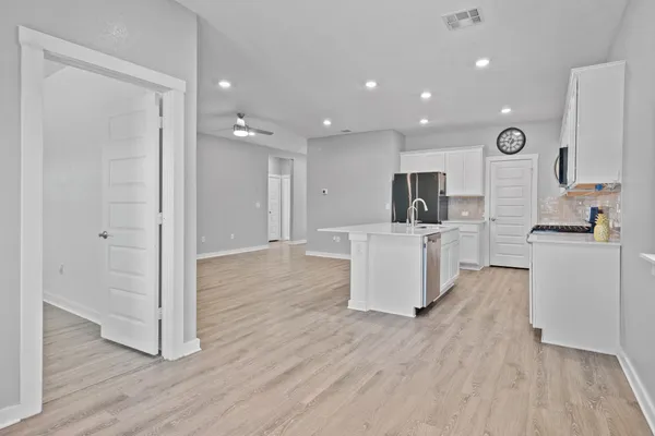 a view of a kitchen with wooden floor and electronic appliances
