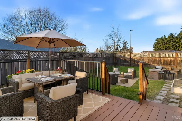 a patio with wooden floor a yard a table and chairs