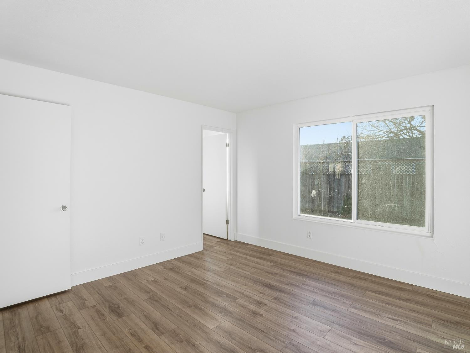6041 Evelyn Avenue Rohnert Park, CA 94928 - Photo 18 of 37 an empty room with wooden floor and windows