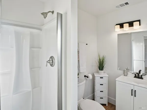 a bathroom with a sink vanity granite and shower