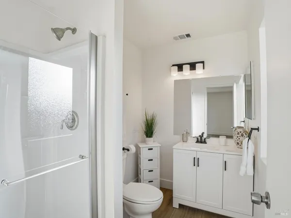a bathroom with a sink a toilet and shower