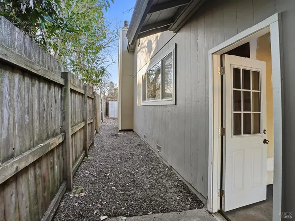 a view of a pathway of a house with wooden fence