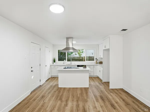 a kitchen with a sink and wooden floor