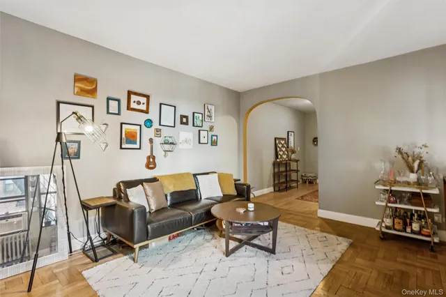 a living room with furniture and a baby crib with wooden floor