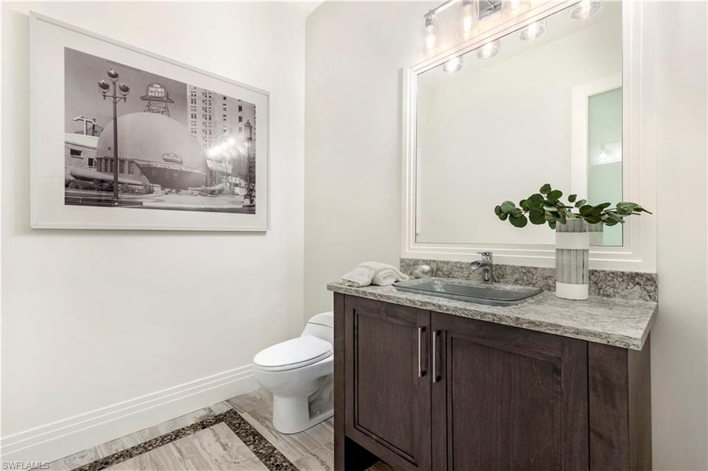 437 West Street Naples, FL 34108 - Photo 11 of 35 a bathroom with a granite countertop sink mirror vanity and toilet