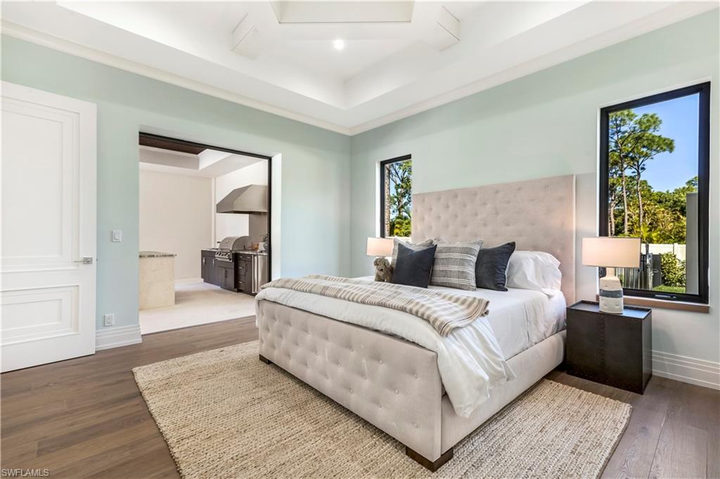 437 West Street Naples, FL 34108 - Photo 21 of 35 a bedroom with a large bed and wooden floor