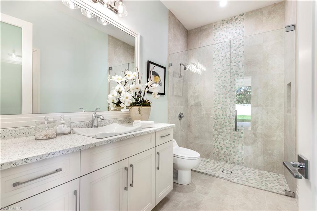 437 West Street Naples, FL 34108 - Photo 22 of 35 a bathroom with a granite countertop sink toilet and shower