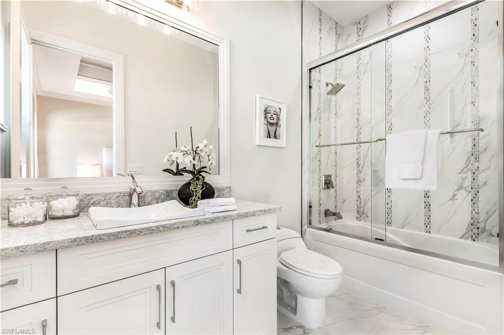 437 West Street Naples, FL 34108 - Photo 24 of 35 a bathroom with a double vanity sink toilet and shower