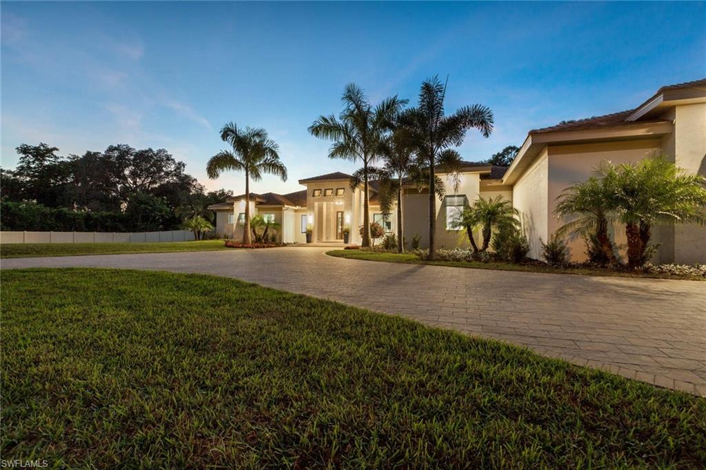 437 West Street Naples, FL 34108 - Photo 33 of 35 a front view of a house with a yard and palm trees