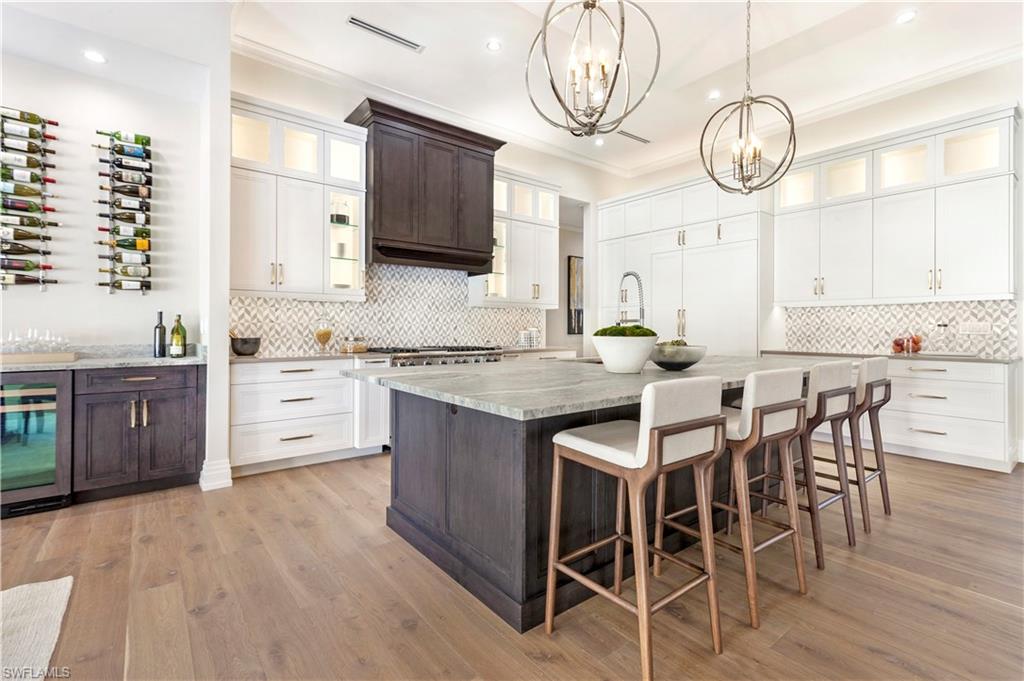 437 West Street Naples, FL 34108 - Photo 8 of 35 a kitchen with stainless steel appliances a table chairs and a refrigerator