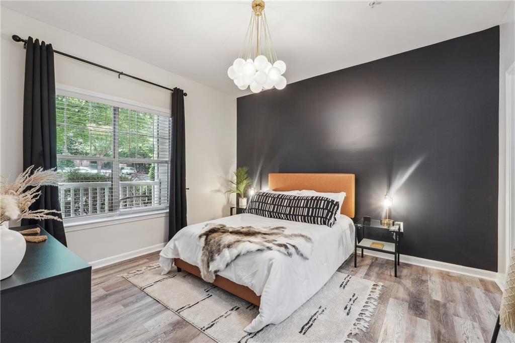 2700 Pine Tree Road Northeast, Unit 2112 Atlanta, GA 30324 - Photo 1 of 1 a bedroom with a large bed and a chandelier