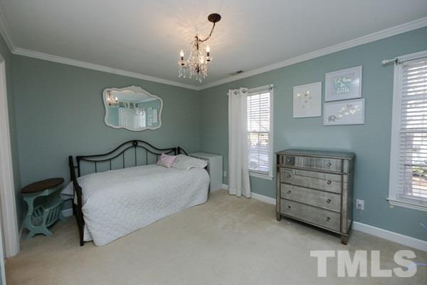 4602 Hamptonshire Drive Raleigh, NC 27613 - Photo 14 of 16 a bedroom with a bed and a chandelier