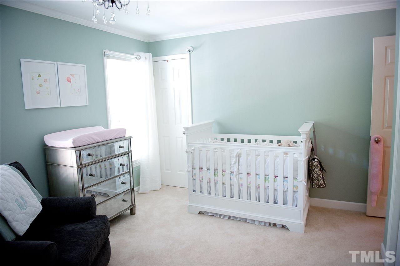 4602 Hamptonshire Drive Raleigh, NC 27613 - Photo 15 of 16 a bedroom with a baby bed a couch and a window in it