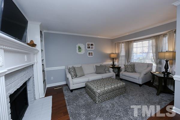 4602 Hamptonshire Drive Raleigh, NC 27613 - Photo 3 of 16 a living room with furniture a flat screen tv and a fireplace