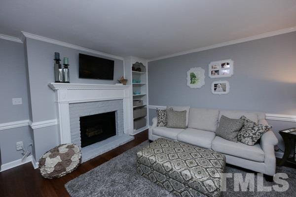 4602 Hamptonshire Drive Raleigh, NC 27613 - Photo 4 of 16 a living room with furniture a flat screen tv and a fireplace