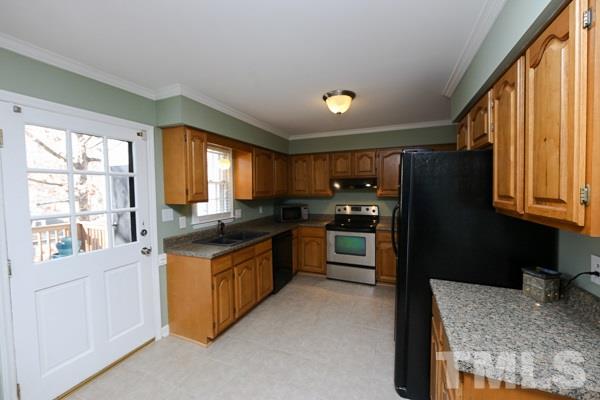 4602 Hamptonshire Drive Raleigh, NC 27613 - Photo 7 of 16 a kitchen with granite countertop a stove a sink and a refrigerator