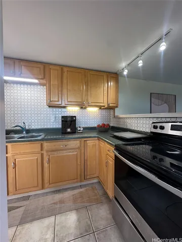 a kitchen with stainless steel appliances granite countertop a sink stove and cabinets