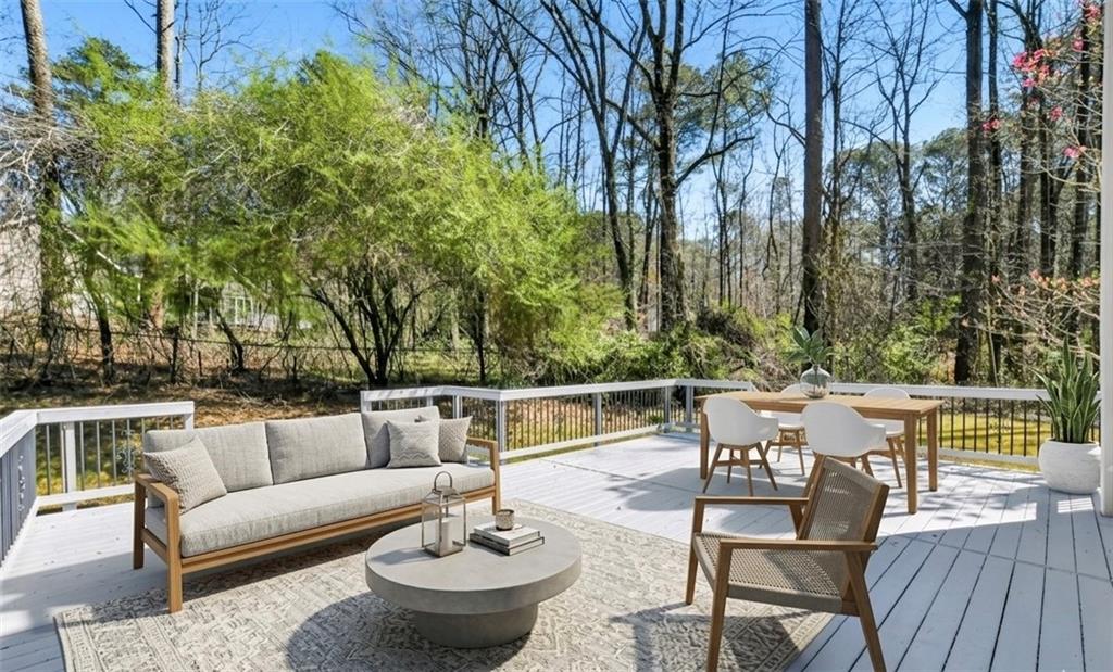 5976 Bowers Road Stone Mountain, GA 30087 - Photo 28 of 31 a view of a patio with couches and a table and chairs with wooden floor