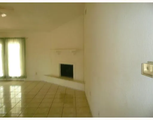 a view of an empty room with a fireplace and a window