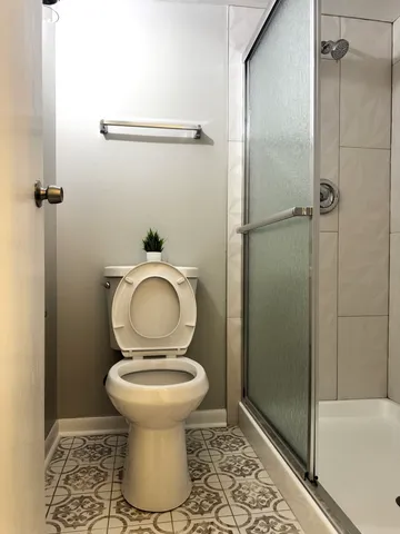 a bathroom with a toilet and a shower
