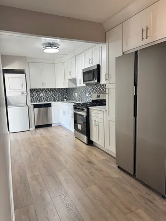 a kitchen with a refrigerator stove top oven and sink