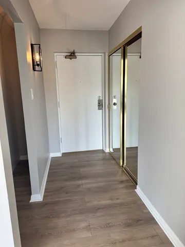 a view of a hallway with wooden floor and staircase