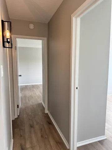 a view of a hallway with wooden floor