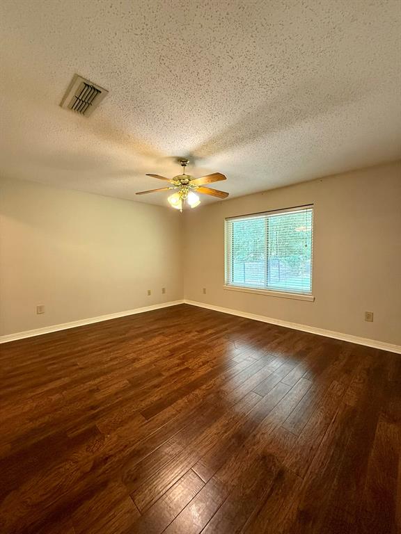 11535 Timber Ridge Drive Keithville, LA 71047 - Photo 24 of 39 an empty room with wooden floor fan and windows