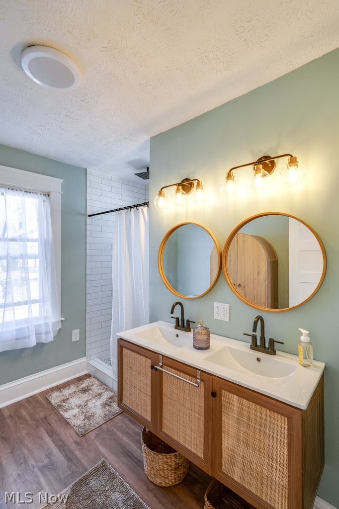 12 South 4th Street Rittman, OH 44270 - Photo 35 of 48 Full bathroom with double vanity, a shower stall, dark wood-style floors, and a textured ceiling