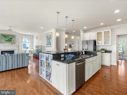 a kitchen with stainless steel appliances granite countertop a stove and a wooden floors