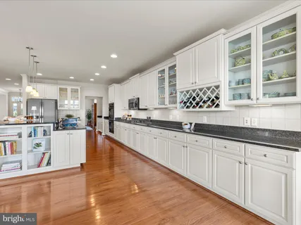 a large white kitchen with kitchen island lots of counter place and a sink