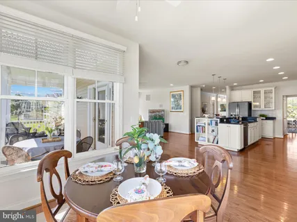 a dining room with furniture a large window and kitchen view