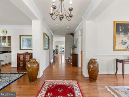 a living room with dining table and a chandelier