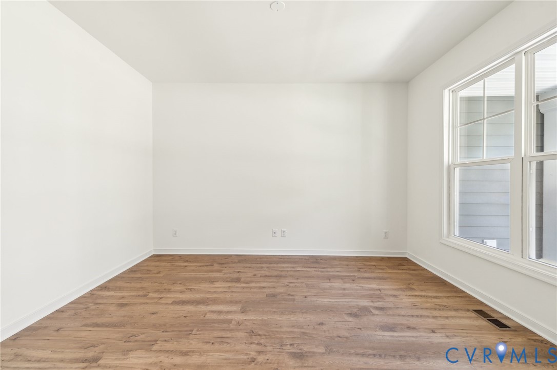 3953 Robins Ridge Drive Moseley, VA 23120 - Photo 13 of 25 a view of an empty room with wooden floor and a window