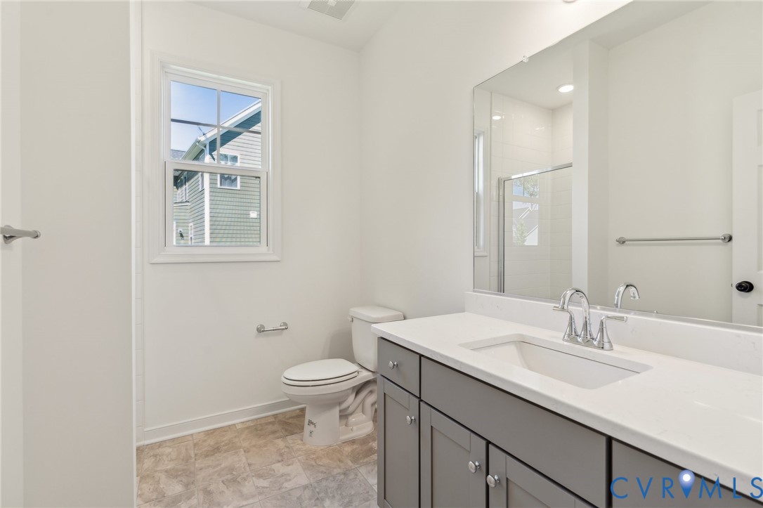 3953 Robins Ridge Drive Moseley, VA 23120 - Photo 16 of 25 a bathroom with a granite countertop sink a toilet and a mirror