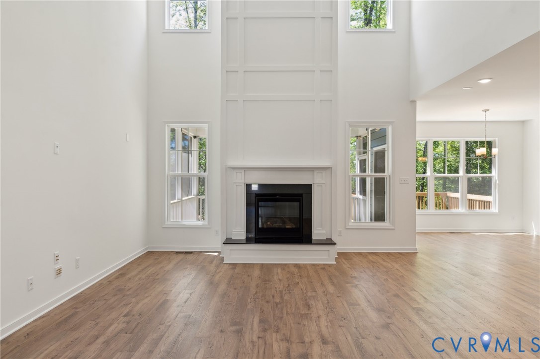3953 Robins Ridge Drive Moseley, VA 23120 - Photo 9 of 25 an empty room with wooden floor fireplace and windows