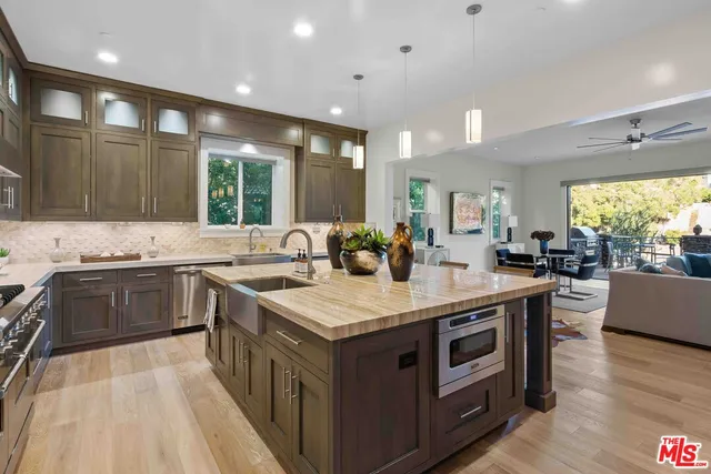 a kitchen with stainless steel appliances granite countertop a sink a stove and a wooden floors