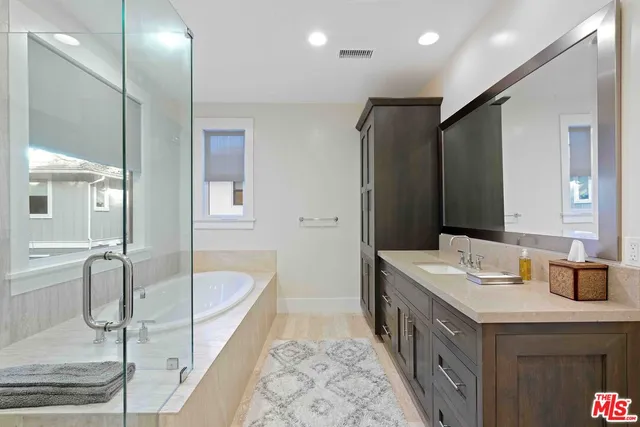 a bathroom with a tub sink and mirror