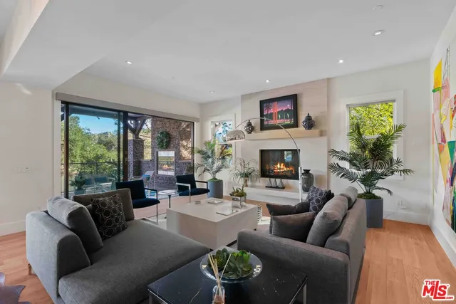 a living room with furniture a large window and a fireplace