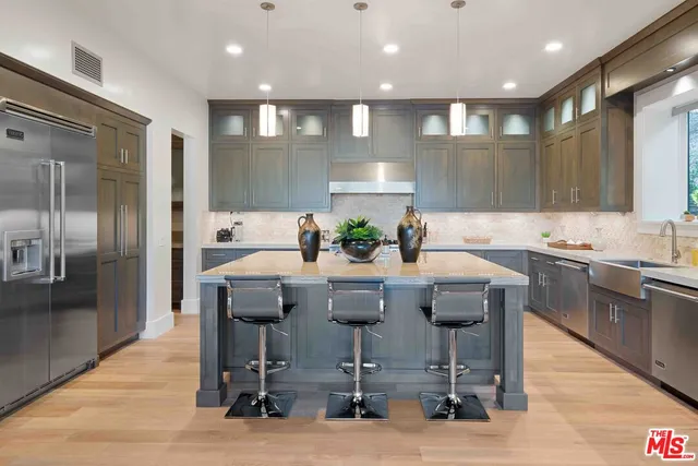 a kitchen with stainless steel appliances kitchen island granite countertop a sink and cabinets