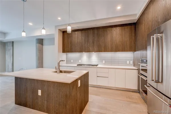 a kitchen with a sink a stove a refrigerator and cabinets