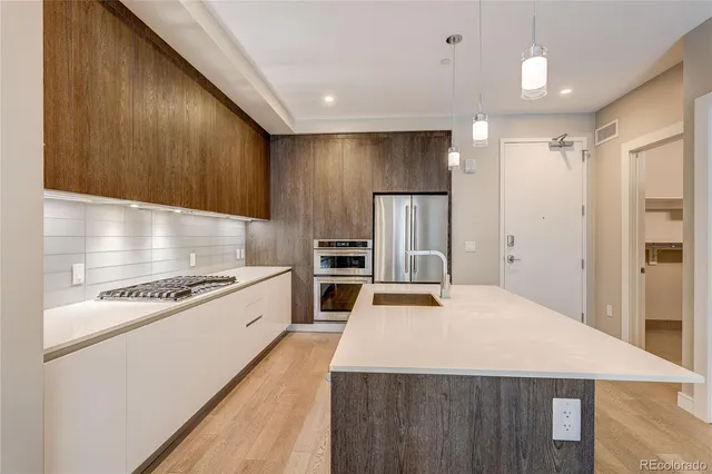 a kitchen with kitchen island a counter space a stove a refrigerator and cabinets