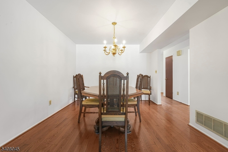 175 Castle Ridge Drive East Hanover, NJ 07936 - Photo 15 of 34 a view of a dining room with furniture a chandelier and wooden floor