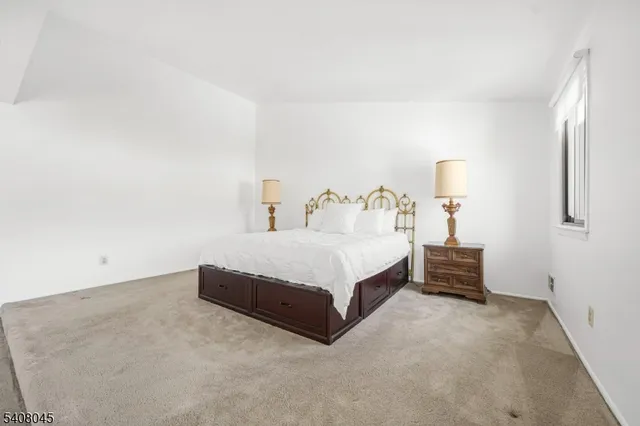 a spacious bedroom with a bed and a cabinets