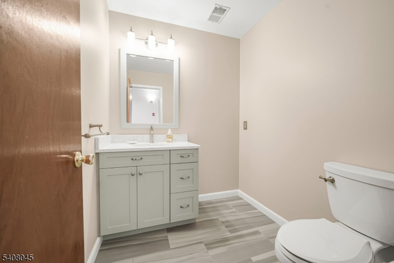 175 Castle Ridge Drive East Hanover, NJ 07936 - Photo 5 of 34 a bathroom with a toilet a sink a mirror and vanity