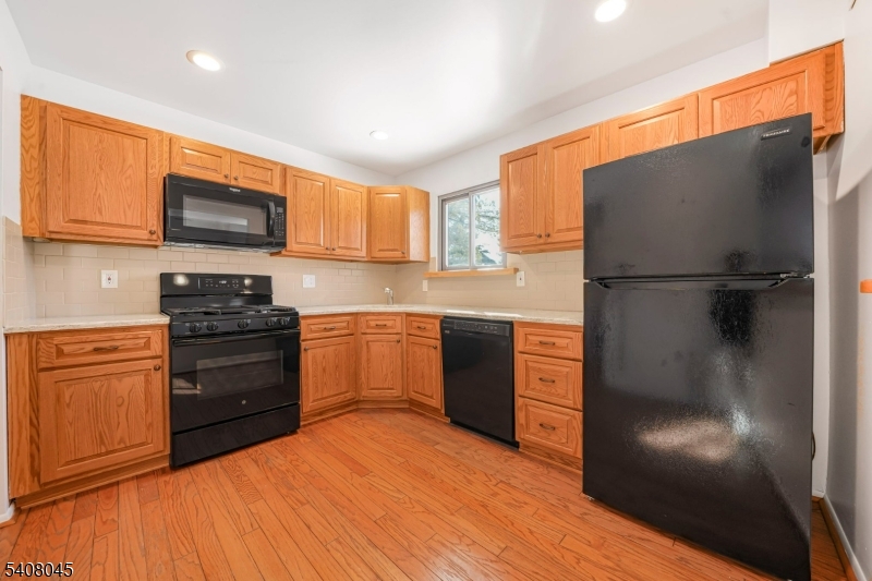 175 Castle Ridge Drive East Hanover, NJ 07936 - Photo 8 of 34 a kitchen with granite countertop stainless steel appliances and wooden cabinets