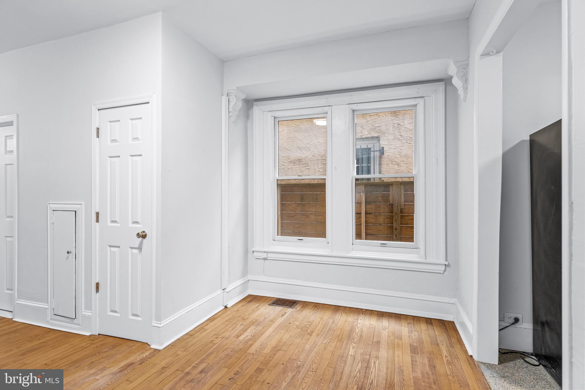 2303 Christian Street, Unit 1 Philadelphia, PA 19146 - Photo 11 of 21 a view of an empty room with wooden floor and a window