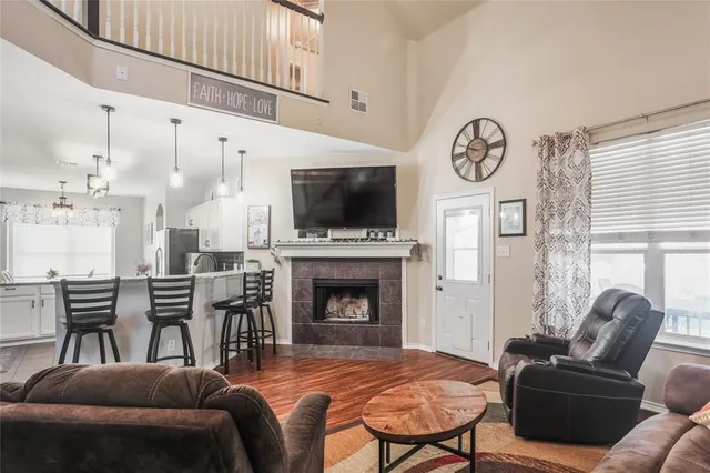 a living room with furniture a fireplace and a flat screen tv