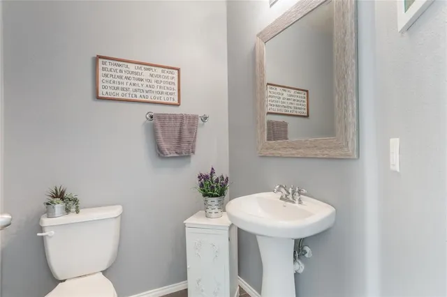 a bathroom with a toilet a sink and mirror
